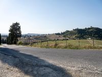 a person on an unicycle riding a bicycle down a country road towards a hill