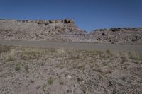 view of the area, including a river bed, rock walls, and scrub grass