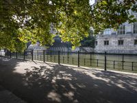 the long walkway passes through the trees by the riverbank and boats are floating on it