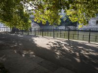 the long walkway passes through the trees by the riverbank and boats are floating on it