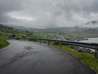 a winding road with a bridge on the side of it surrounded by mountains and water