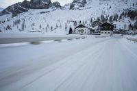 the car travels along the mountainous road on snowy day - like terrain, driving through snow - covered mountains and forest