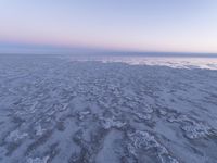 a view of an ice covered lake and the sky on a clear day at dusk