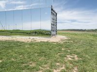 the large mirrored cube in a field is a unique sight to see it as if not in a mirror