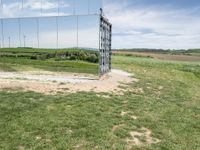 the large mirrored cube in a field is a unique sight to see it as if not in a mirror