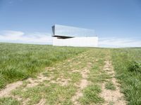 an upside down structure that is sitting on top of a field of grass and some dirt