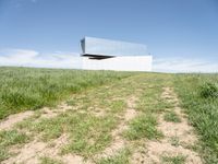 an upside down structure that is sitting on top of a field of grass and some dirt