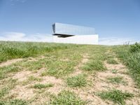 an upside down structure that is sitting on top of a field of grass and some dirt