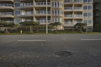 a fire hydrant sits on the sidewalk in front of a tall building with balconies