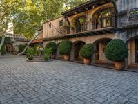 the courtyard and entrance to an apartment complex, with patios, bushes, and trees