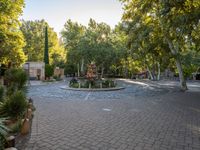 there is a very pretty outdoor area with some fountains and trees surrounding it a very quiet place to sit