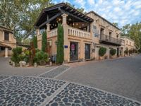 a cobblestone paved area with a building in the background and an awning