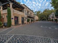 a cobblestone paved area with a building in the background and an awning