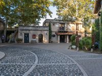 a large cobblestone courtyard and some buildings on each side of it's path