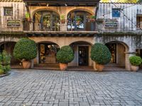 a courtyard in an old italian town with a few potted trees and planters