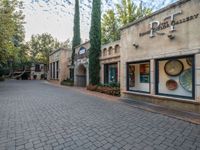 an entrance of a building with a bunch of trees surrounding it and a blue door is at the front