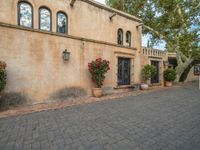 there is a courtyard area with brick walkways and plants growing on the walls and windows