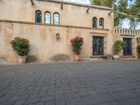 a building with many planters in front of it that is standing on top of a brick floor