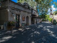 an image of a cobblestone street with buildings and trees surrounding it in the background