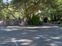 a brick driveway with an archway and walkway in front of it that has a planter