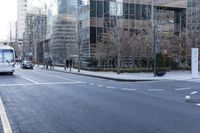 an empty city street filled with lots of traffic on the side of it and people waiting on a bench