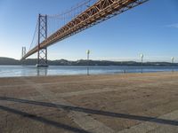 a person riding a bike on the side of a road near the bridge over water