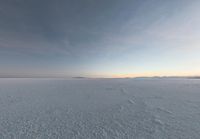 a man that is snow skiing on some ice field land in the winter time looking back to the camera