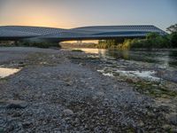 there are two very long bridges that are above the river shore at dusk here, and you can see how close them are