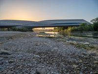 there are two very long bridges that are above the river shore at dusk here, and you can see how close them are