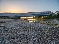 there are two very long bridges that are above the river shore at dusk here, and you can see how close them are