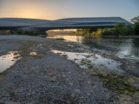 there are two very long bridges that are above the river shore at dusk here, and you can see how close them are