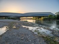 there are two very long bridges that are above the river shore at dusk here, and you can see how close them are