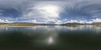 a lake that is very calm with no water in it, and a bright sun shines brightly through the cloud