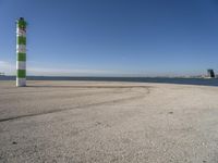 a person sitting on the beach in front of the ocean, looking at the water