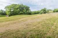 an empty field with a stop sign and poles in the background at high speed on a cloudy day