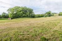 an empty field with a stop sign and poles in the background at high speed on a cloudy day