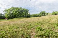 an empty field with a stop sign and poles in the background at high speed on a cloudy day