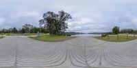 there is a street scene looking at a water and trees in the background in this view from 360 point perspective