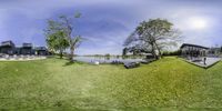 the fish eye view shows what looks like a body of water, and on it's banks and grass