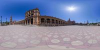 a building with an intricate mosaic pattern on the ground underneath it and a sky in the background