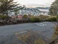 the sign is painted on the side of the street with a view of a city