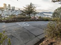 the sign is painted on the side of the street with a view of a city