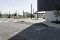 the shadow of a bench on the pavement on a parking lot with some light poles in the background