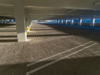 an empty parking garage on the side of the street filled with vehicles and parked cars