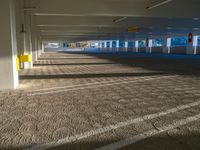 an empty parking garage on the side of the street filled with vehicles and parked cars