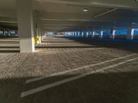 an empty parking garage on the side of the street filled with vehicles and parked cars