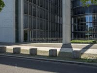 the shadow of a person is projected on some concrete posts near a tree and building