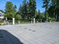 the shadow of a person sits on a concrete ground next to a white building and some trees