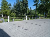 the shadow of a person sits on a concrete ground next to a white building and some trees