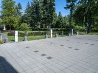the shadow of a person sits on a concrete ground next to a white building and some trees